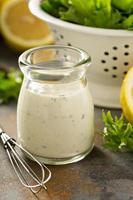 hausgemachtes Lemon-Ranch-Dressing in einem kleinen Glas foto