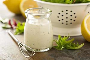 hausgemachtes Lemon-Ranch-Dressing in einem kleinen Glas foto