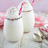 Vanille-Milchshake mit Schlagsahne und Streuseln foto