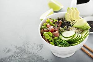 Poke Bowl mit rohem Thunfisch, Reis und Gemüse foto