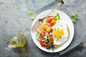 Mehrkorntoast mit Spiegelei und gerösteten Tomaten foto