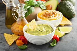 Guacamole und Hummus in weißen Schalen foto