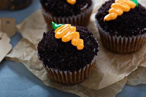 Karotten-Cupcakes mit Schokoladenbröseln und Zuckerguss foto