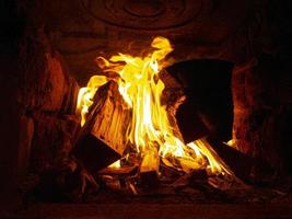 Orange brennendes Holz in einem Steinofen im Inneren, Feuer im Kamin foto