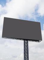 Outdoor-Pfosten-Plakatwand mit verspottetem weißem Bildschirm auf blauem Himmelshintergrund mit Beschneidungspfad foto