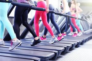 Gruppe von Frauen, die auf dem Laufband joggen foto