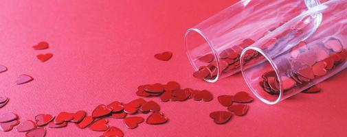 Glas Champagner mit roten Herzen auf rotem Grund. valentinsgrußhintergrund, liebe, datumskonzept mit kopienraum. Banner foto