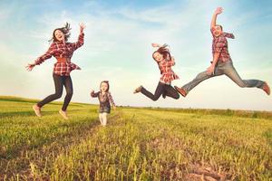 Familie springt auf dem Feld foto