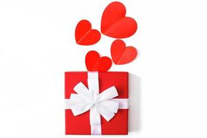 Geschenkbox mit roten Herzen auf weißem Hintergrund. Grußkarte foto