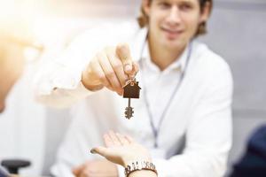 Mittelteil von Immobilienmaklern und Käuferhänden mit Schlüsseln foto