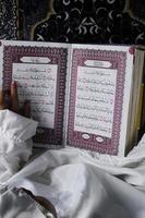 kleines Mädchen, das den Koran liest. islamisches Konzept foto