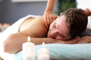 Schöner Mann mit Massage im Spa-Salon foto