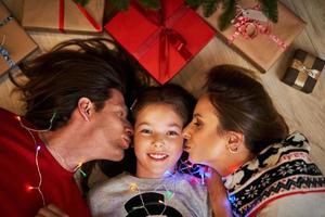 schöne familie mit geschenken unter dem weihnachtsbaum foto