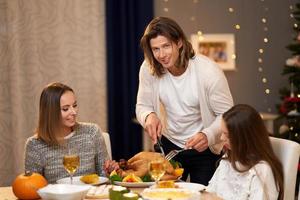 schöne familie, die zu hause weihnachtsessen isst foto