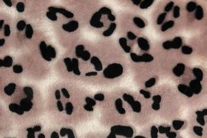 Nahaufnahmemuster aus Fleece-Stoff mit Leopardenmuster. braun-beige und schwarz gestreifte Wiederholung auf der Oberfläche von Pelzkleidung, abstrakter Texturhintergrund. foto