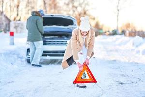 Paar, das während der Winterreise Probleme mit dem Auto hat foto