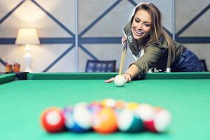 hübsche Frau, die Billard spielt foto