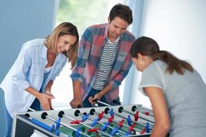 Gruppe von Studenten, die auf dem Campus Tischfußball spielen foto