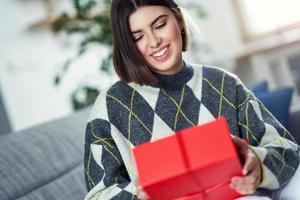 Bild zeigt Frau mit Geschenk zu Hause foto