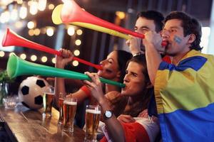 Gruppe von Freunden, die in der Kneipe Fußball schauen foto