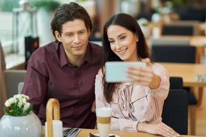 junges Paar macht Selfie im Café foto