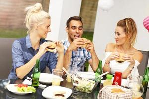 gruppe von freunden, die hamburger essen foto