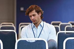 junger Mann sitzt allein im Konferenzraum foto