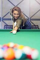 hübsche Frau, die Billard spielt foto