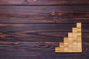 ein Holzklotzwürfel über schwarzem strukturiertem Hintergrund aus Holz mit Kopierraum zum Hinzufügen von Worttexttiteln. konzept oder konzeptionelle holzblocktreppe oder sechs stufen. kubisch foto