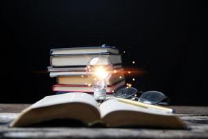 Glühbirnen und Bücher. Konzept des Lesens von Büchern, Wissen und der Suche nach neuen Ideen. Innovation und Inspiration, Kreativität mit funkelnden Lichtern, die Inspiration von Ideen. foto