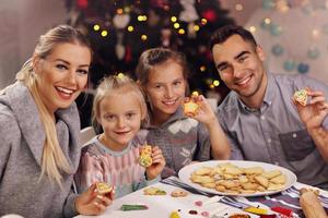 Fröhliche Familie, die Weihnachtskekse zubereitet foto