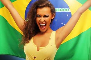 glücklicher brasilianischer fan, der mit flagge jubelt foto