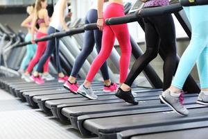 Gruppe von Frauen, die auf dem Laufband joggen foto