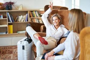 Zwei Geschäftsfrauen mit Gepäck in der modernen Hotellobby foto