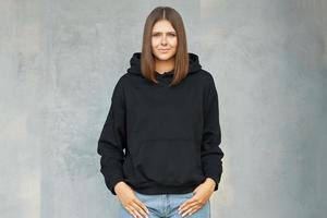 junge Frau im schwarzen Hoodie. foto