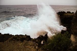 starke Wellen, die auf die Felsen treffen foto