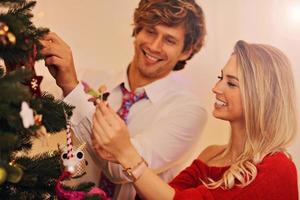 glückliches paar, das weihnachtsbaum schmückt foto