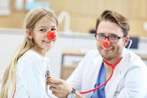 kleines Mädchen in der Klinik, das sich beim Kinderarzt untersuchen lässt foto