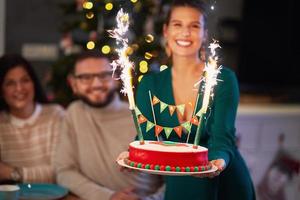 gruppe von freunden, die weihnachten zu hause mit ausgefallenem kuchen feiern foto