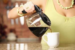 Frau gießt Kaffee ein foto