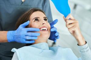 männlicher zahnarzt und frau in der zahnarztpraxis foto