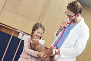 Arzt begrüßt kleines Mädchen in der Klinik foto