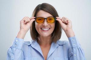 attraktive Frau mit gelb-blauer Blockierbrille isoliert auf weißem Hintergrund foto