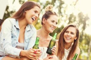 glückliche gruppe von freunden, die draußen bier trinken foto