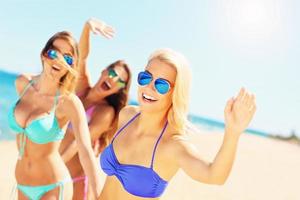 Gruppe von Frauen, die sich am Strand amüsieren foto