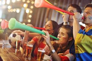 Gruppe von Freunden, die in der Kneipe Fußball schauen foto