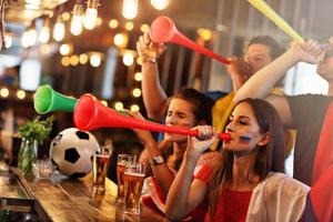 Gruppe von Freunden, die in der Kneipe Fußball schauen foto