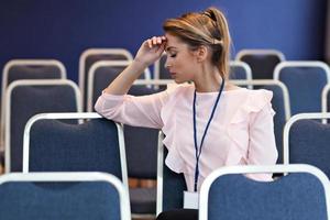 junge Frau sitzt allein im Konferenzraum foto