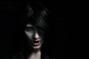 Halloween-Vampir schöne Frau über schwarz foto