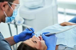 männlicher zahnarzt und frau in der zahnarztpraxis